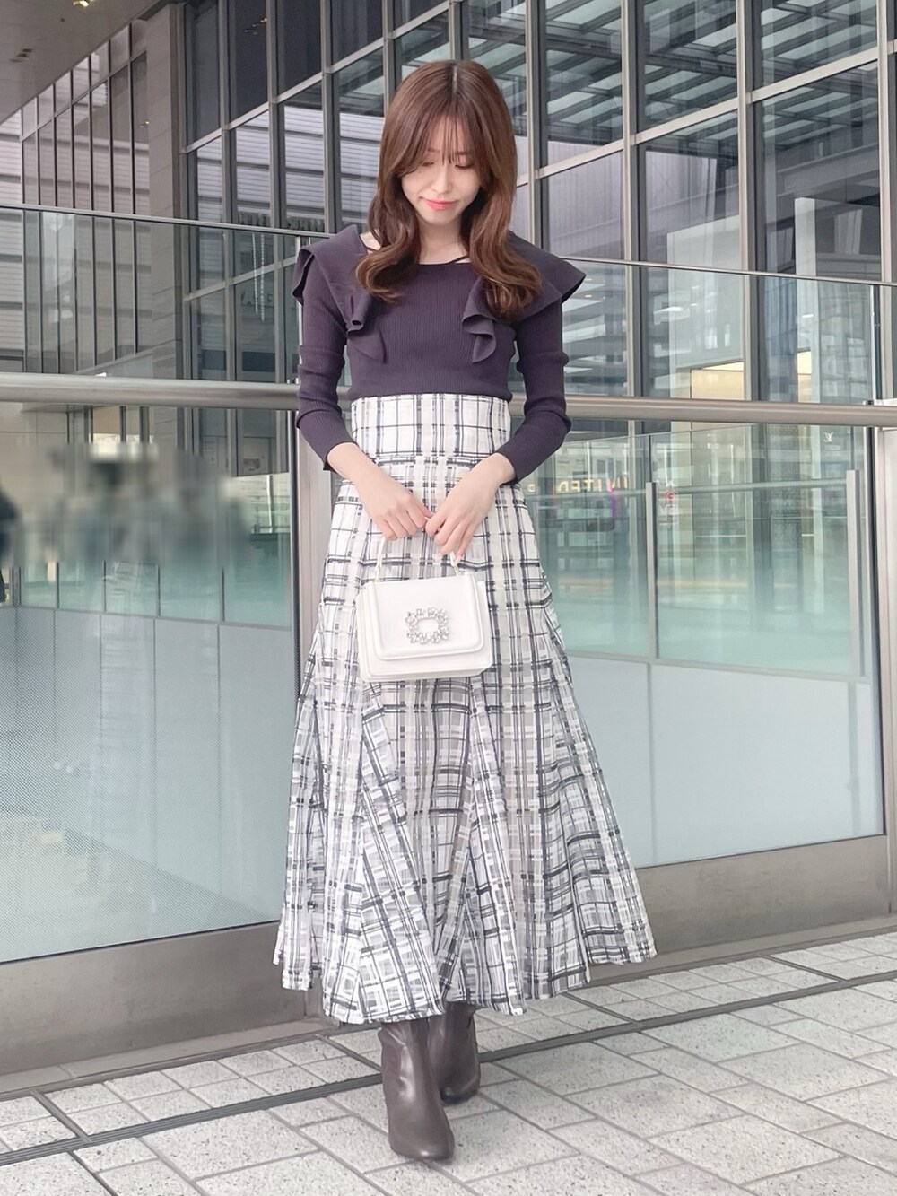 ホワイト系のショルダーバッグ、グレー系のニット/セーター、ホワイト系のチェスターコートを着用したレディースの冬コーディネートの4枚目の写真