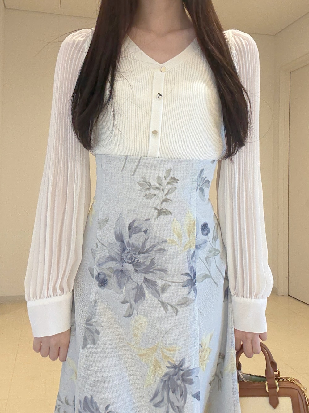 ホワイト系のニット/セーター、グリーン系のスカート、ブラウン系のハンドバッグを着用したレディースの冬コーディネートの6枚目の写真