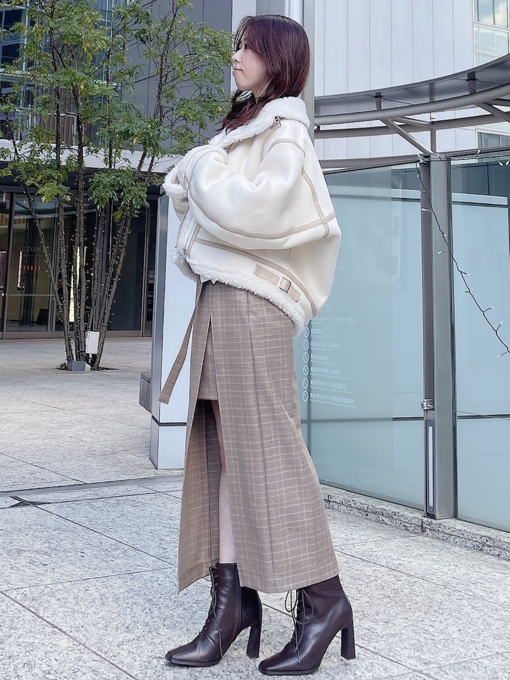ホワイト系のムートンコート、ホワイト系のニット/セーター、ベージュ系のスカートを着用したレディースの冬コーディネートの3枚目の写真