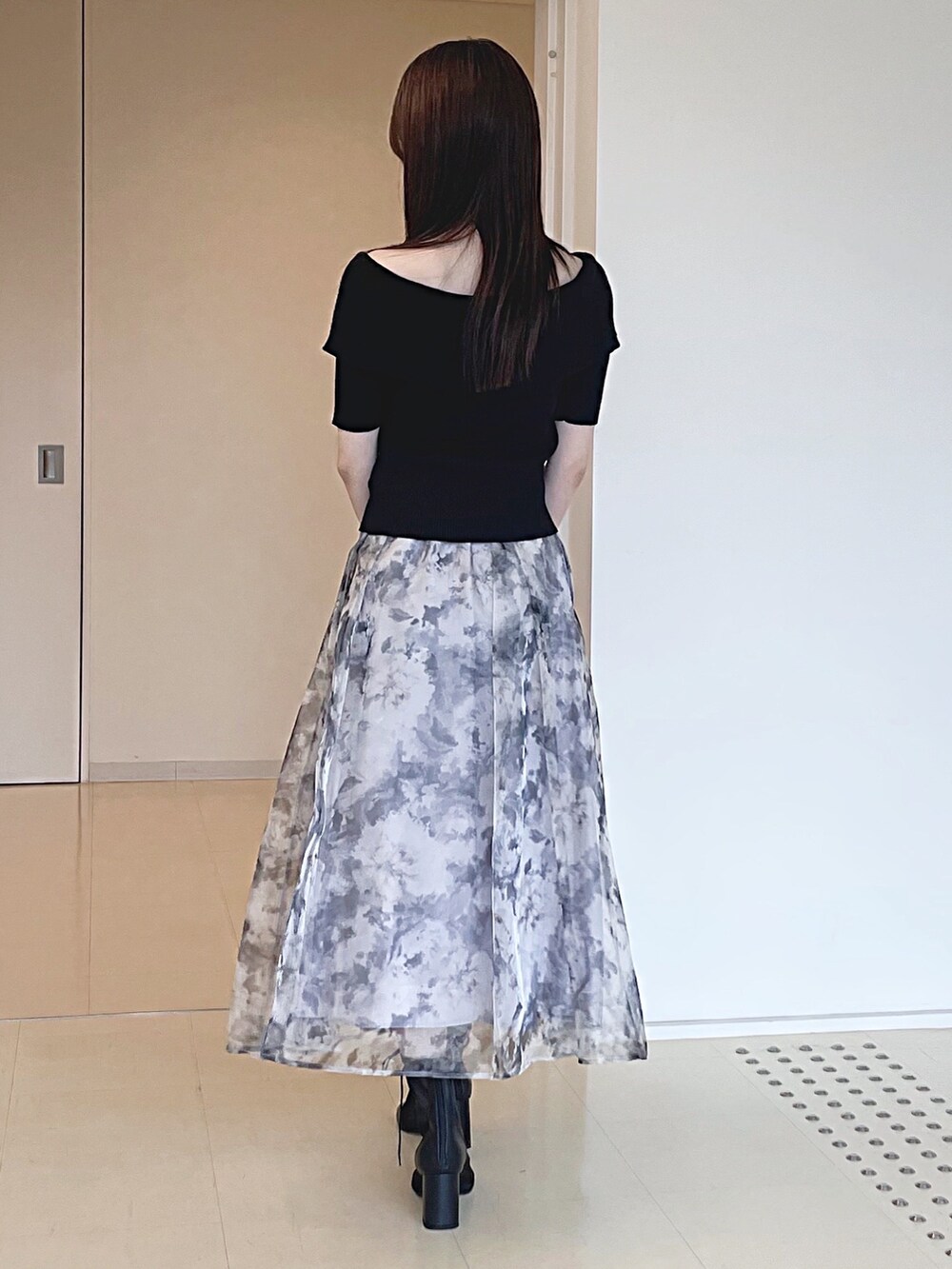 ブラック系のニット/セーター、グレー系のスカート、シルバー系のハンドバッグを着用したレディースの夏コーディネートの5枚目の写真