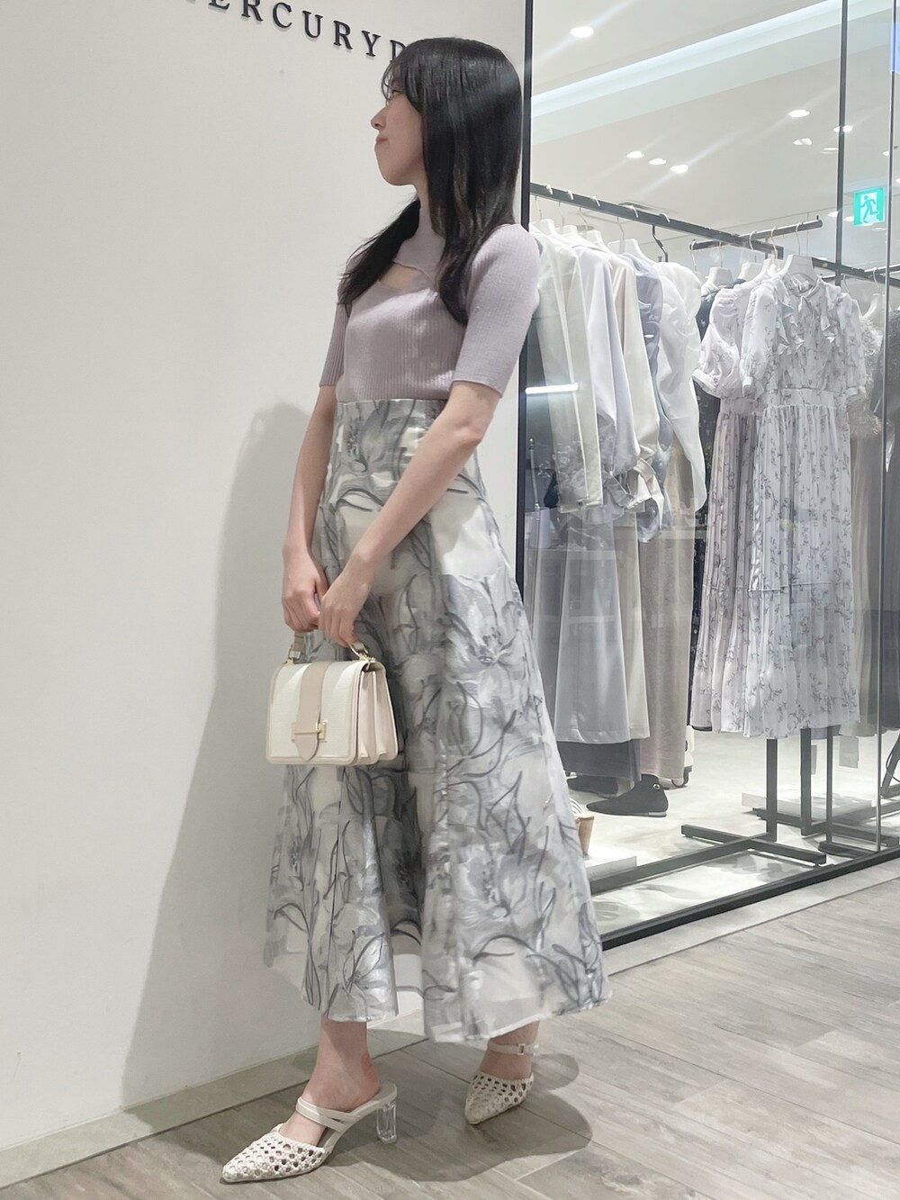 ホワイト系のパンプス、ピンク系のニット/セーター、グレー系のスカートを着用したレディースの春コーディネートの3枚目の写真