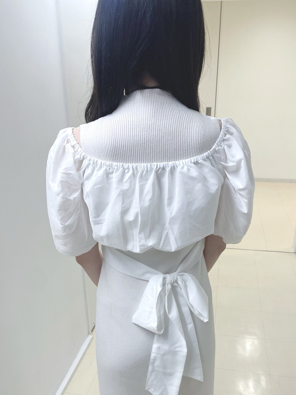 ホワイト系のワンピース、ブラック系のハンドバッグ、ホワイト系のブーツを着用したレディースの春コーディネートの8枚目の写真