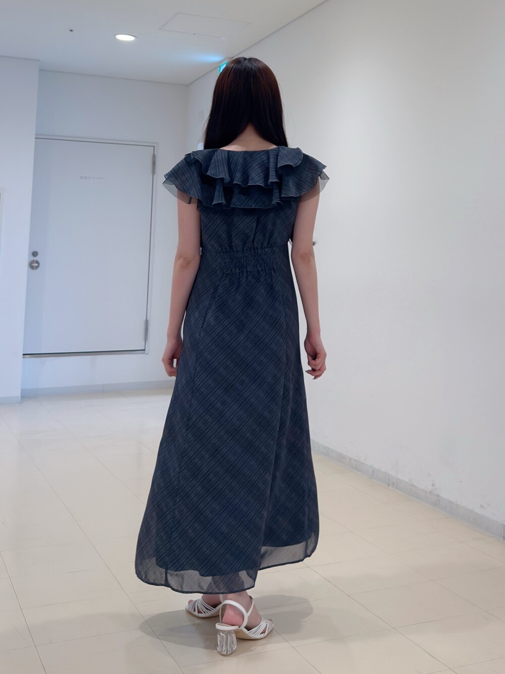 ブラック系のワンピース、ホワイト系のサンダルを着用したレディースの夏コーディネートの4枚目の写真