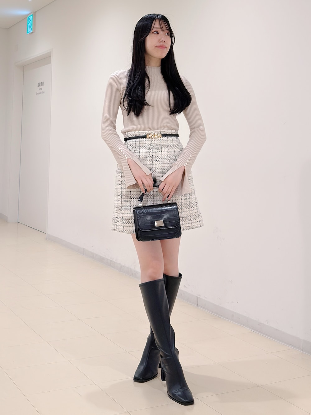 ベージュ系のニット/セーター、ホワイト系のスカート、ブラック系のハンドバッグを着用したレディースの秋コーディネートの3枚目の写真