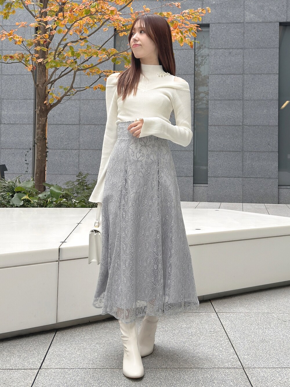 ホワイト系のハンドバッグ、ホワイト系のブーツ、ホワイト系のニット/セーターを着用したレディースの冬コーディネートの4枚目の写真