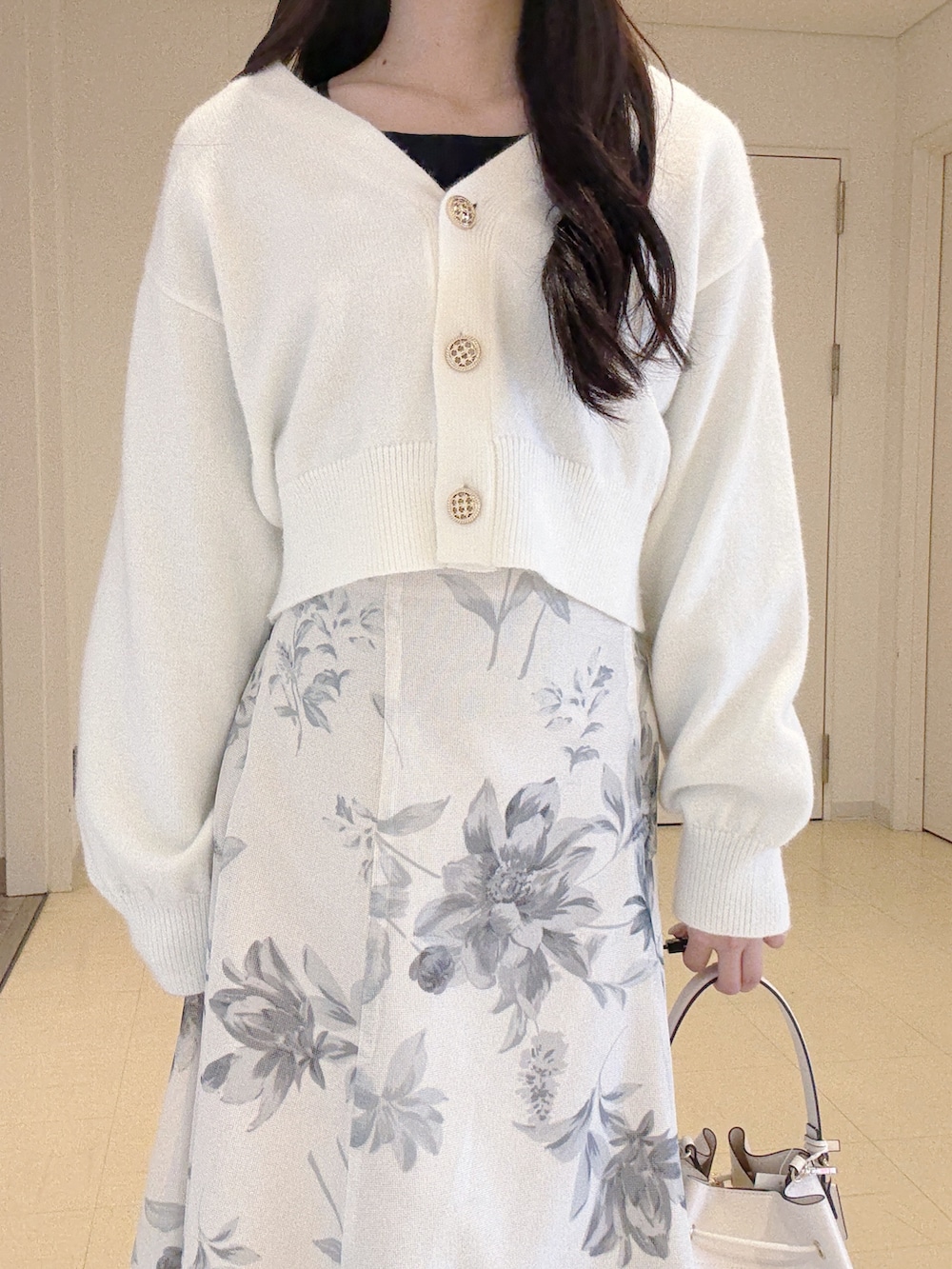 ホワイト系のカーディガン/ボレロ、ホワイト系のスカート、ホワイト系のショルダーバッグを着用したレディースの冬コーディネートの6枚目の写真