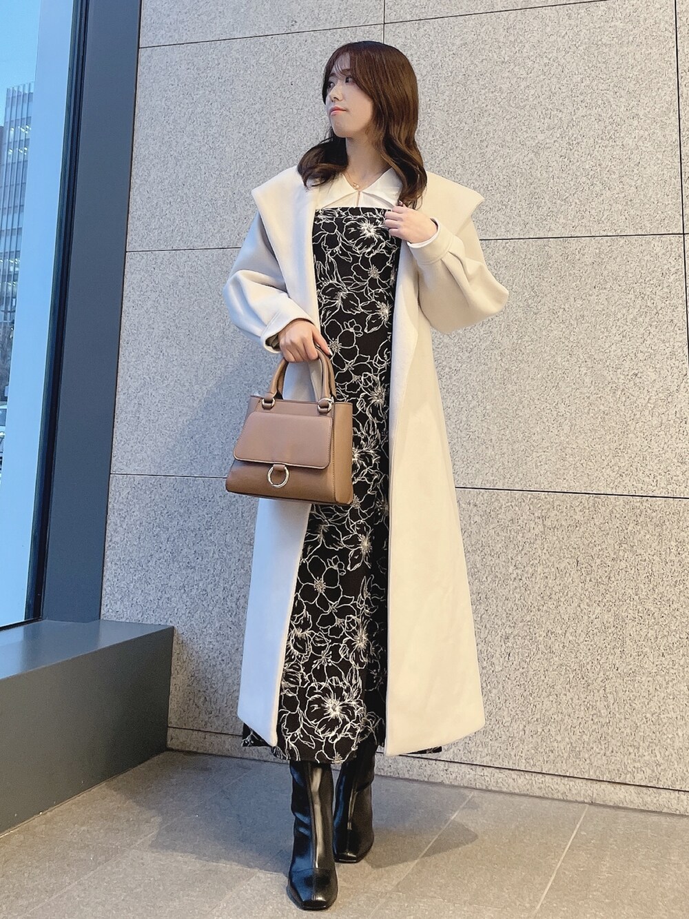 ブラック系のブーツ、その他のワンピース、ブラウン系のハンドバッグを着用したレディースの冬コーディネートの3枚目の写真