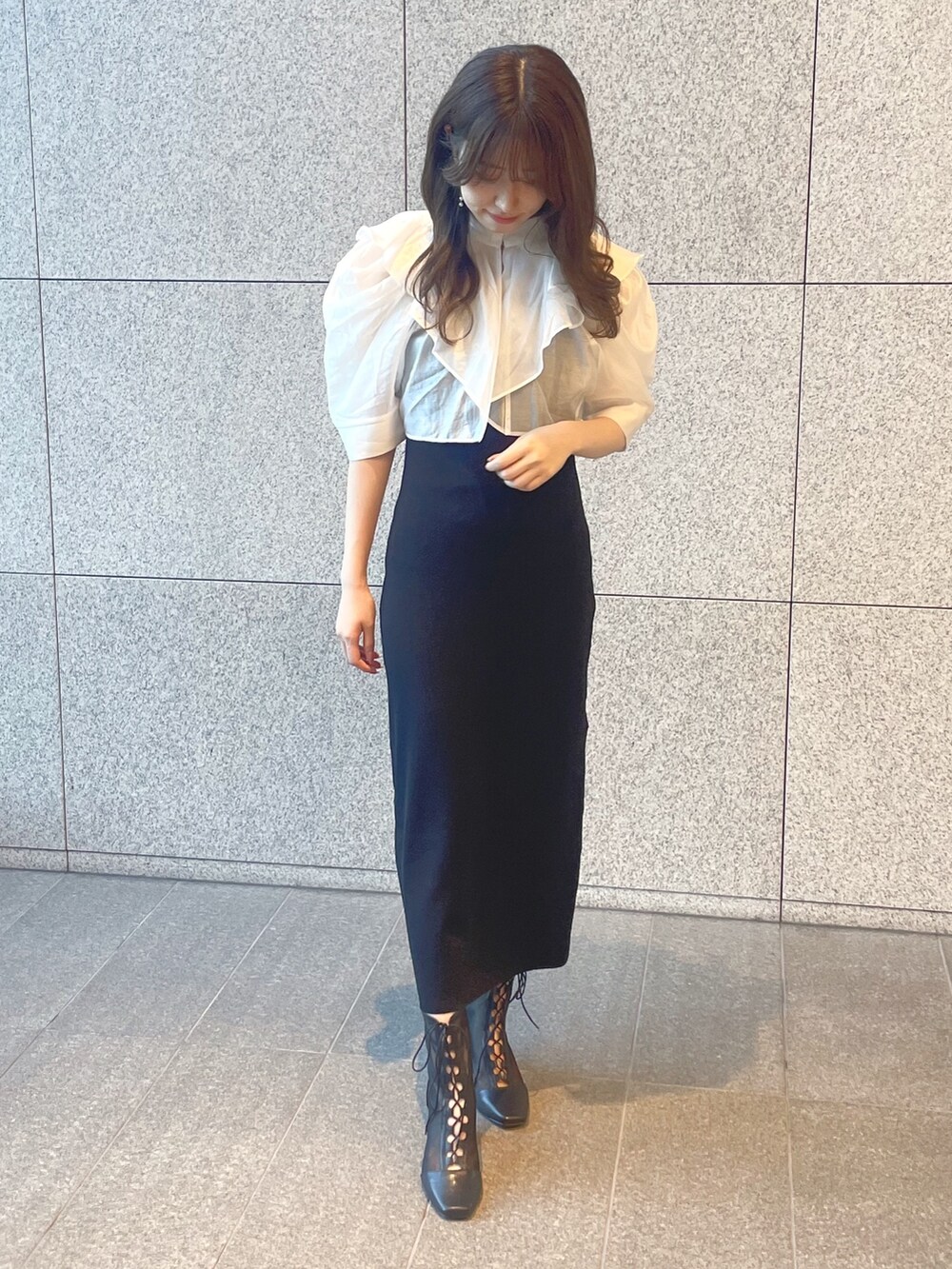 ブラック系のワンピース、シルバー系のハンドバッグ、ブラック系のブーツを着用したレディースの夏コーディネートの3枚目の写真