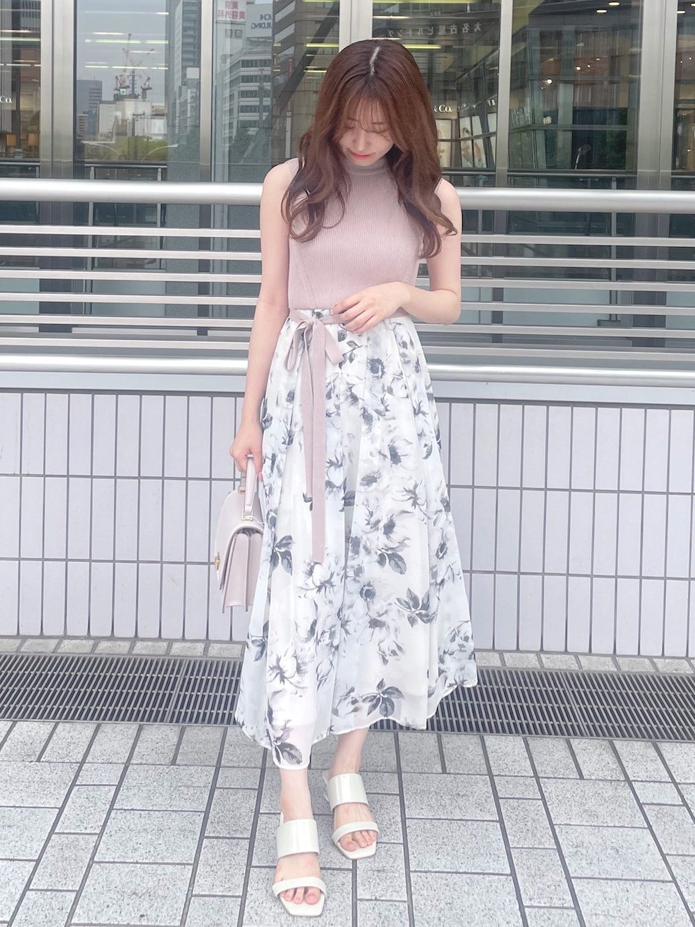 ベージュ系のワンピース、ピンク系のハンドバッグ、ホワイト系のサンダルを着用したレディースの夏コーディネートの3枚目の写真