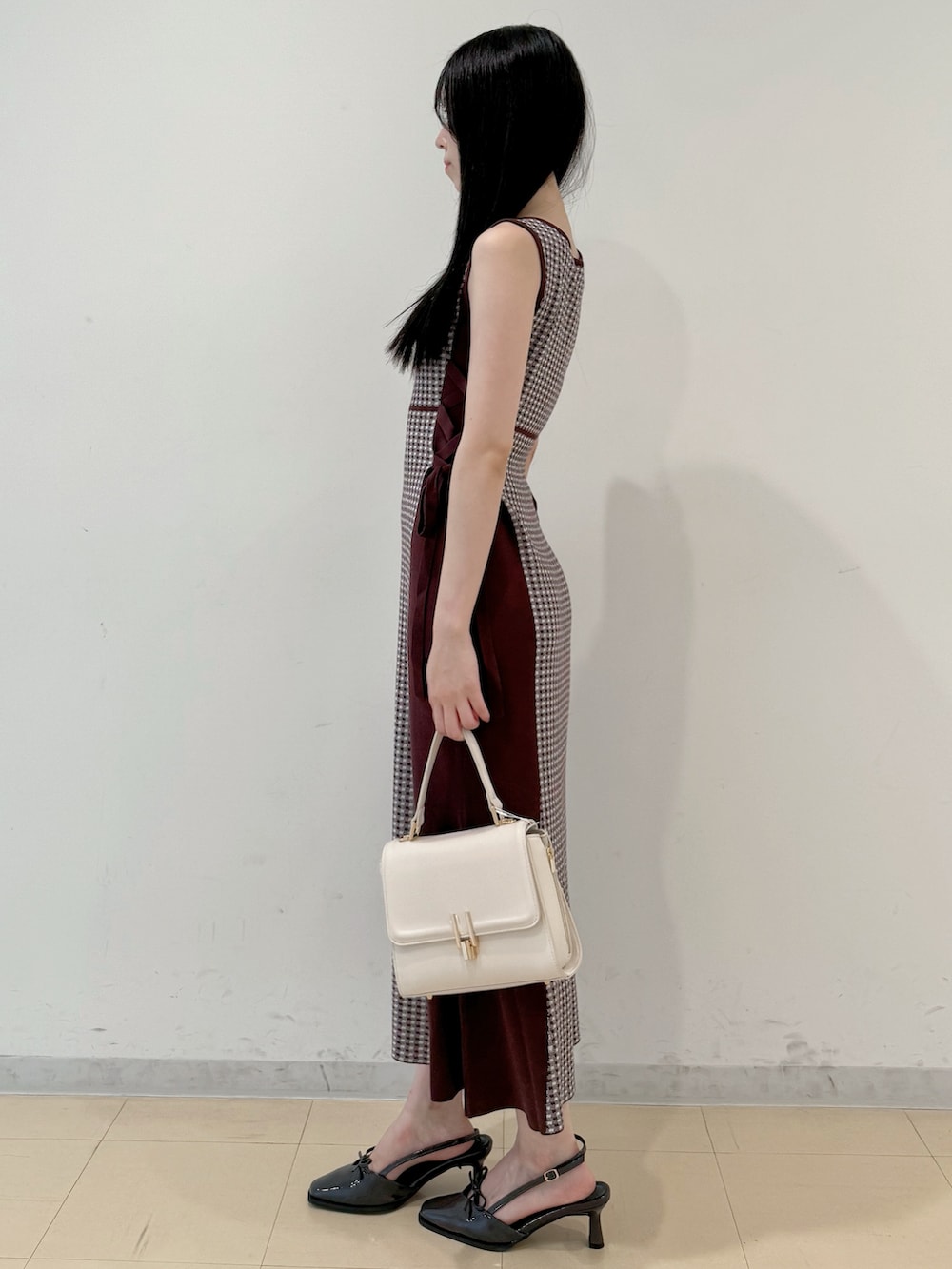 ブラウン系のワンピース、ホワイト系のハンドバッグ、グレー系のパンプスを着用したレディースの夏コーディネートの5枚目の写真