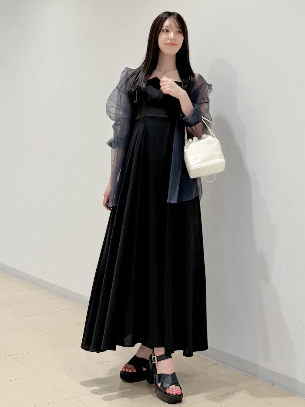 グレー系のシャツ/ブラウス、ブラック系のワンピース、ホワイト系のハンドバッグを着用したレディースの春コーディネートの2枚目の写真