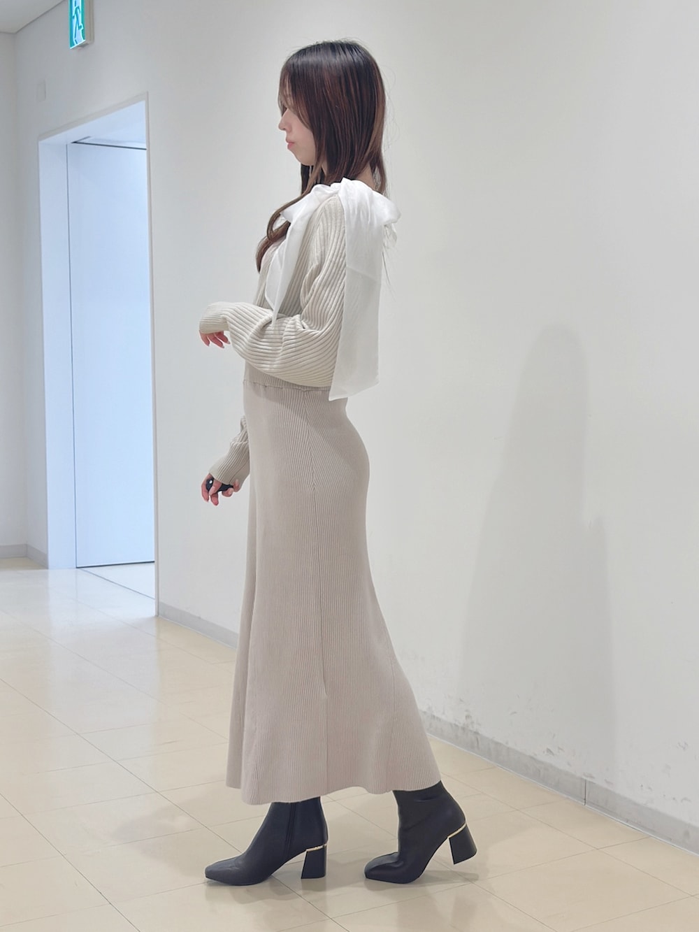 ホワイト系のワンピース、ブラウン系のブーツを着用したレディースの冬コーディネートの3枚目の写真