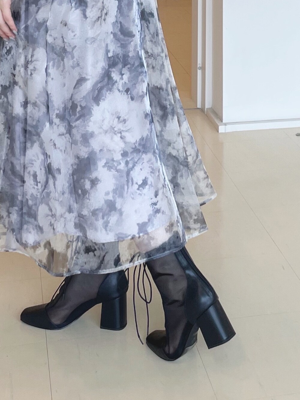 ブラック系のニット/セーター、グレー系のスカート、シルバー系のハンドバッグを着用したレディースの夏コーディネートの6枚目の写真