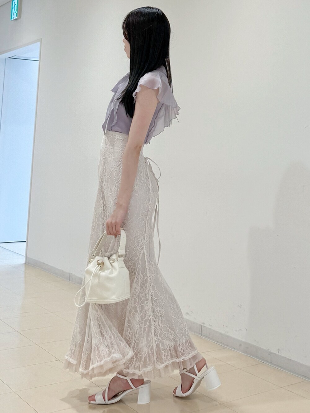 ホワイト系のスカート、ホワイト系のサンダル、ホワイト系のハンドバッグを着用したレディースの春コーディネートの4枚目の写真