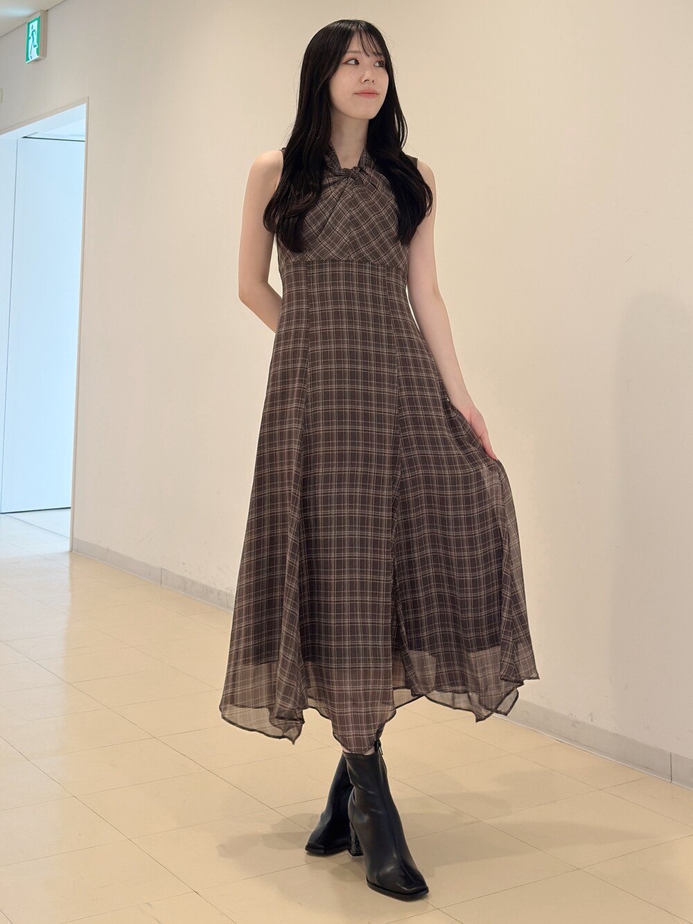 ホワイト系のカーディガン/ボレロ、ブラウン系のワンピース、ブラック系のブーツを着用したレディースの夏コーディネートの6枚目の写真