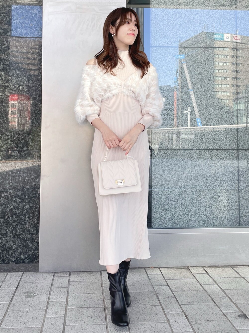 ベージュ系のワンピース、ホワイト系のショルダーバッグ、ブラック系のブーツを着用したレディースの冬コーディネートの2枚目の写真