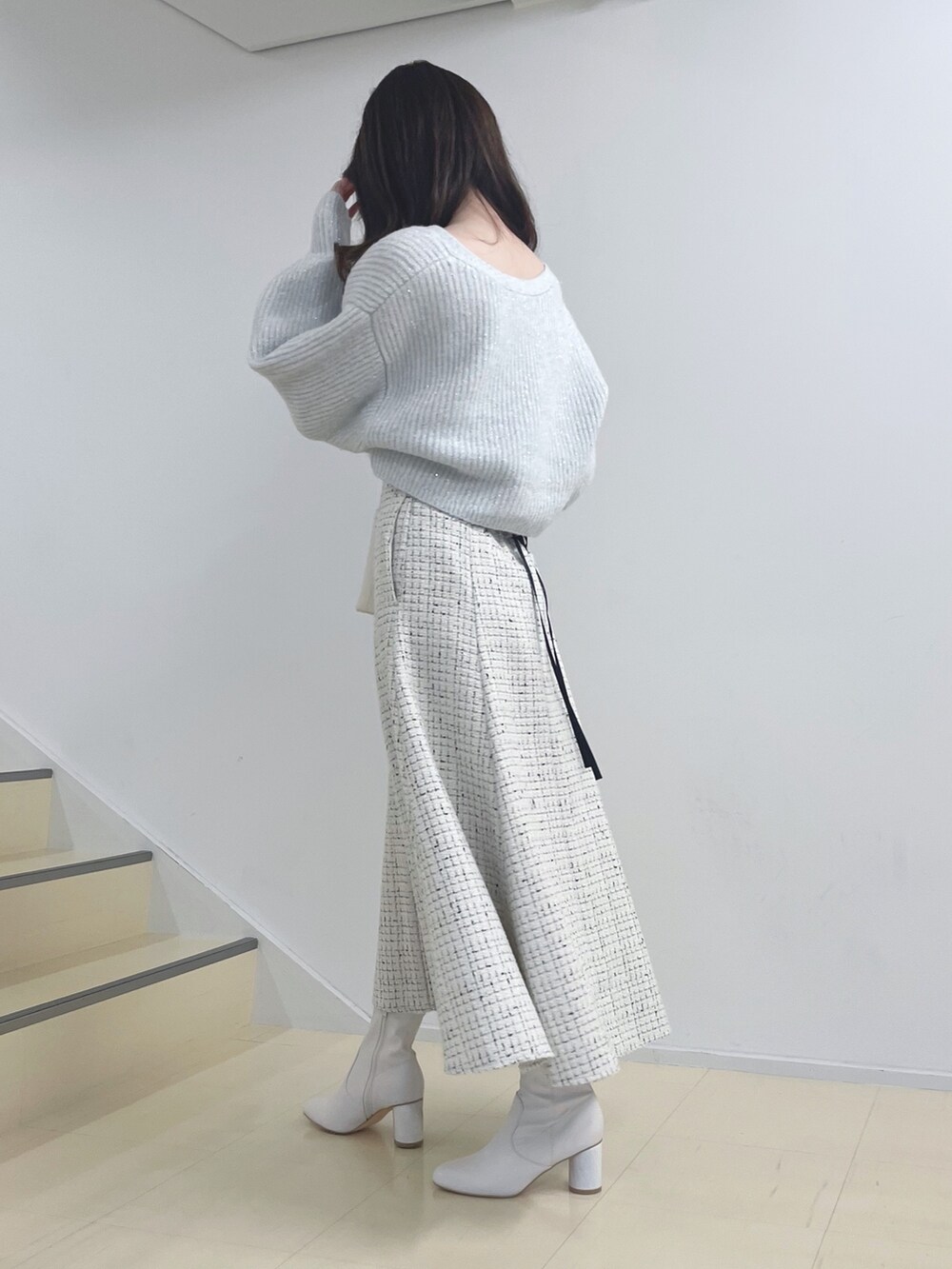 ホワイト系のニット/セーター、ホワイト系のスカート、ホワイト系のハンドバッグを着用したレディースの秋コーディネートの5枚目の写真