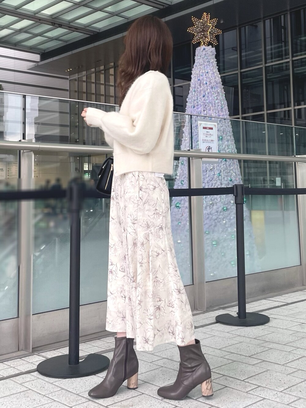 ホワイト系のカーディガン/ボレロ、ホワイト系のワンピース、ブラック系のショルダーバッグを着用したレディースの秋コーディネートの4枚目の写真