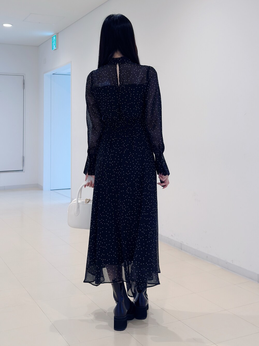 その他のワンピース、ホワイト系のハンドバッグ、ブラック系のブーツを着用したレディースの秋コーディネートの5枚目の写真