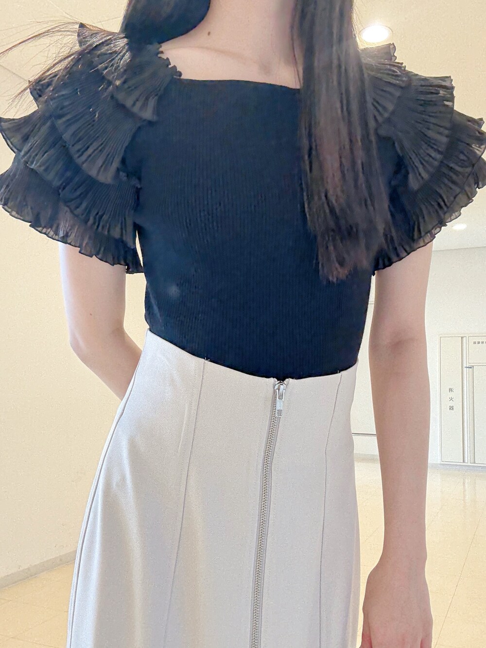 ブラック系のニット/セーター、グレー系のスカート、ホワイト系のハンドバッグを着用したレディースの夏コーディネートの6枚目の写真