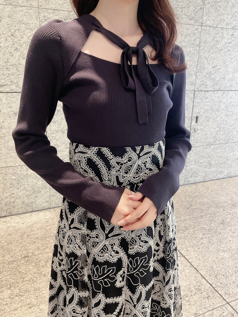 ブラウン系のニット/セーター、ブラック系のスカート、ホワイト系のブーツを着用したレディースの冬コーディネートの3枚目の写真