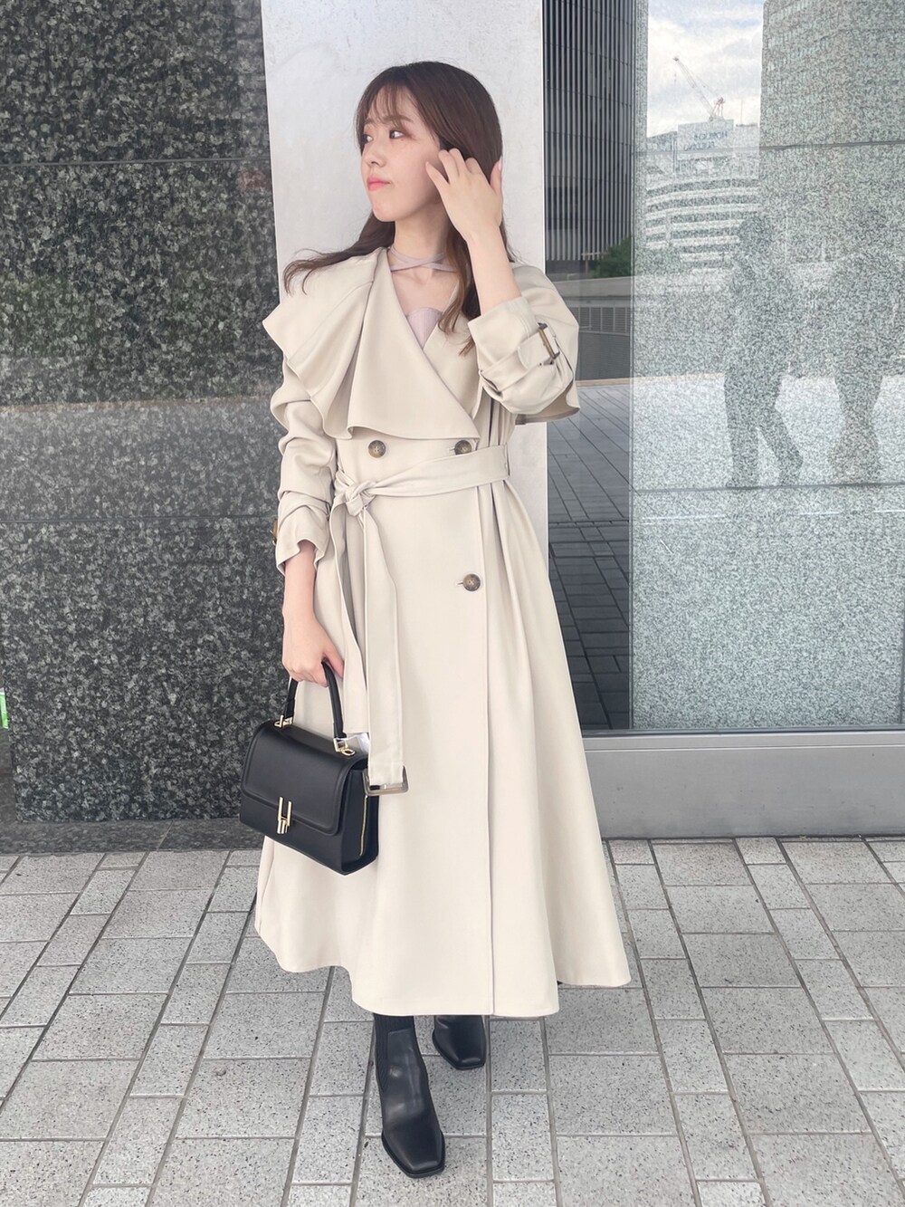ピンク系のワンピース、ベージュ系のトレンチコート、ブラック系のショルダーバッグを着用したレディースの秋コーディネートの3枚目の写真