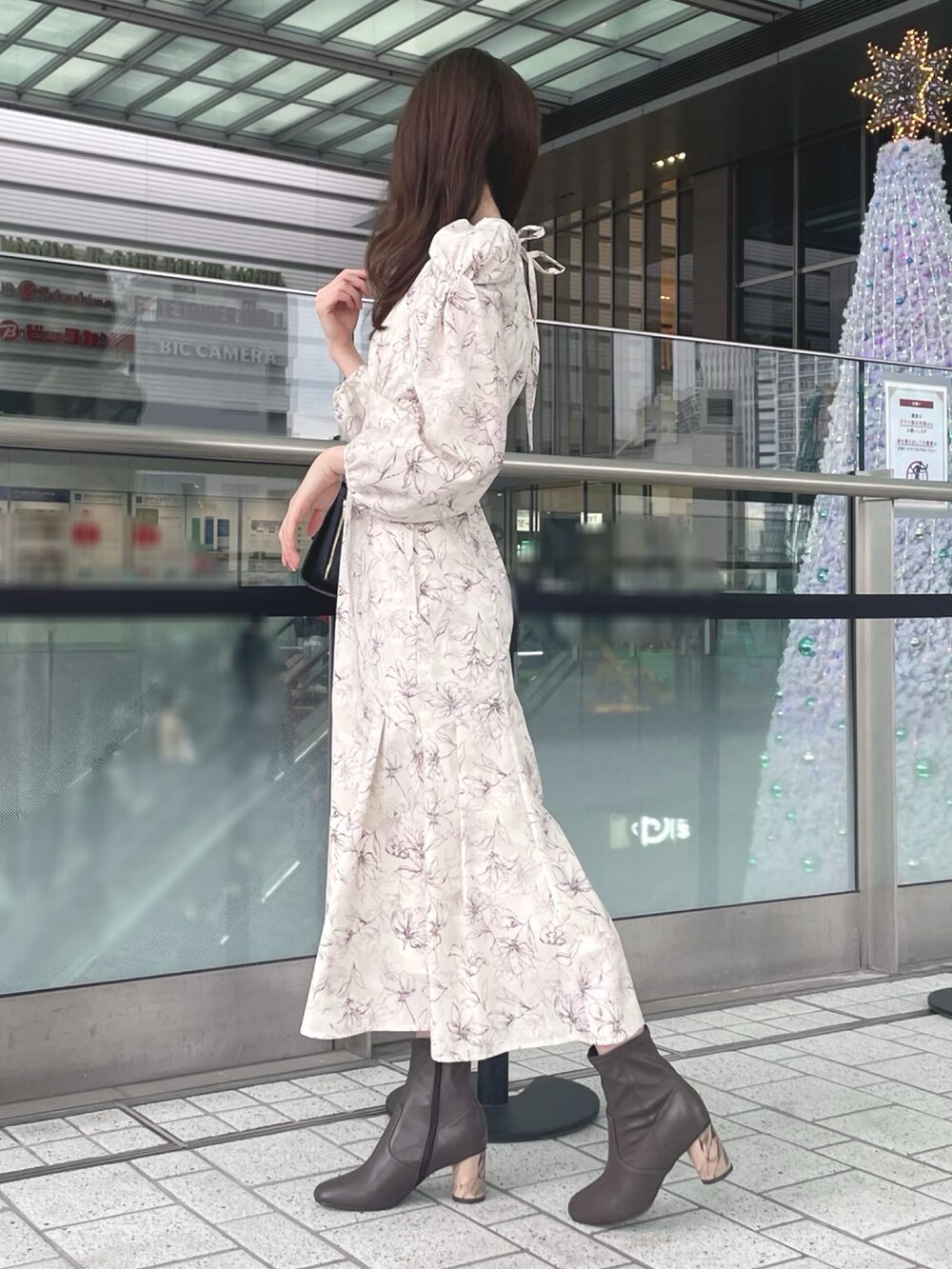 ホワイト系のカーディガン/ボレロ、ホワイト系のワンピース、ブラック系のショルダーバッグを着用したレディースの秋コーディネートの7枚目の写真