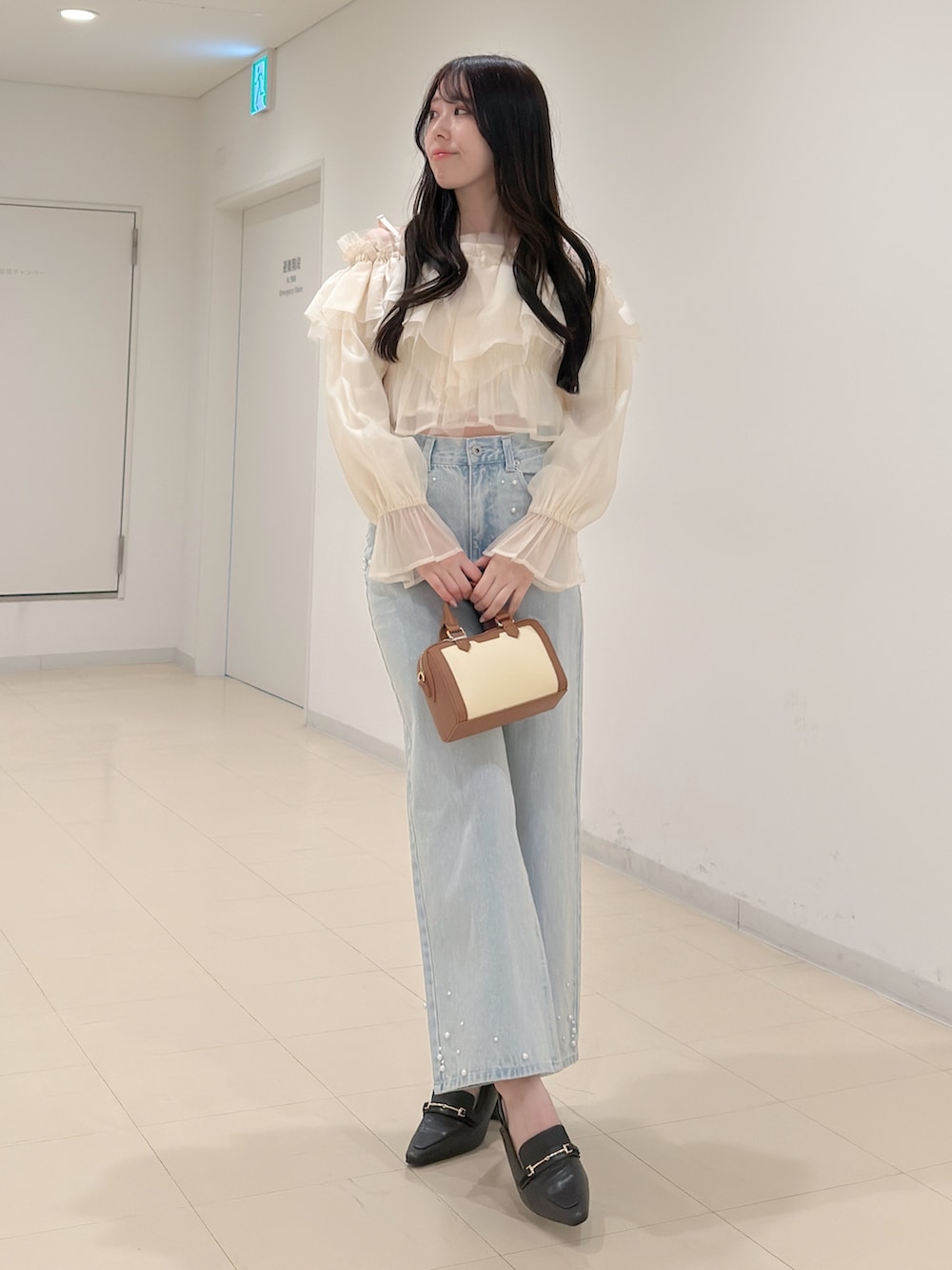 ホワイト系のシャツ/ブラウス、ブルー系のデニムパンツ、ブラウン系のハンドバッグを着用したレディースの春コーディネートの2枚目の写真