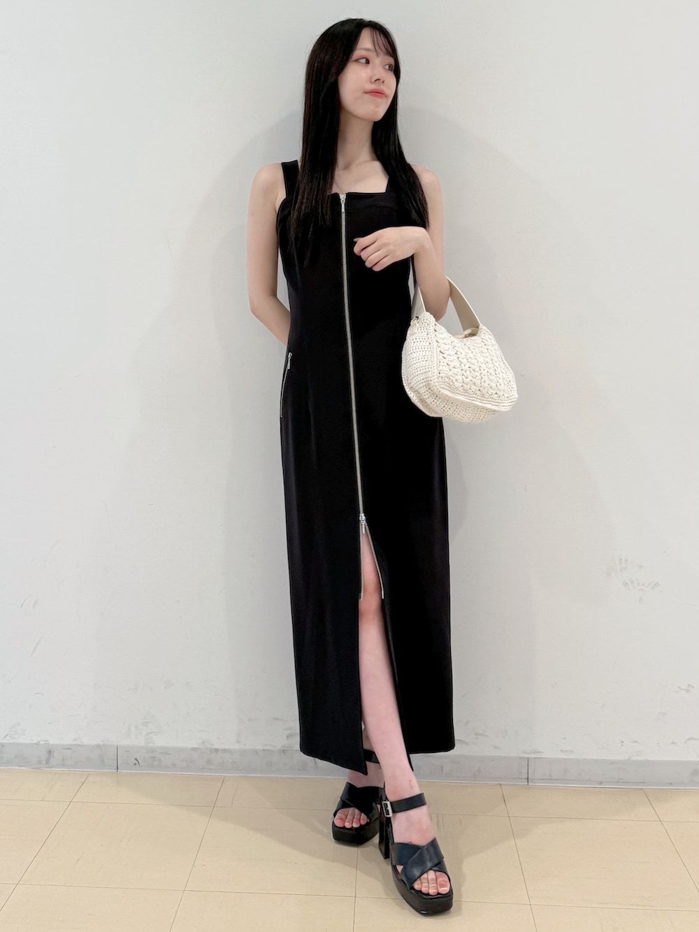 ブラック系のワンピース、ホワイト系のショルダーバッグ、ブラック系のサンダルを着用したレディースの夏コーディネートの3枚目の写真