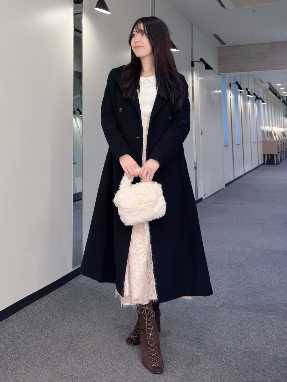 ブラック系のその他アウター、ホワイト系のニット/セーター、ピンク系のスカートを着用したレディースの秋コーディネートの3枚目の写真