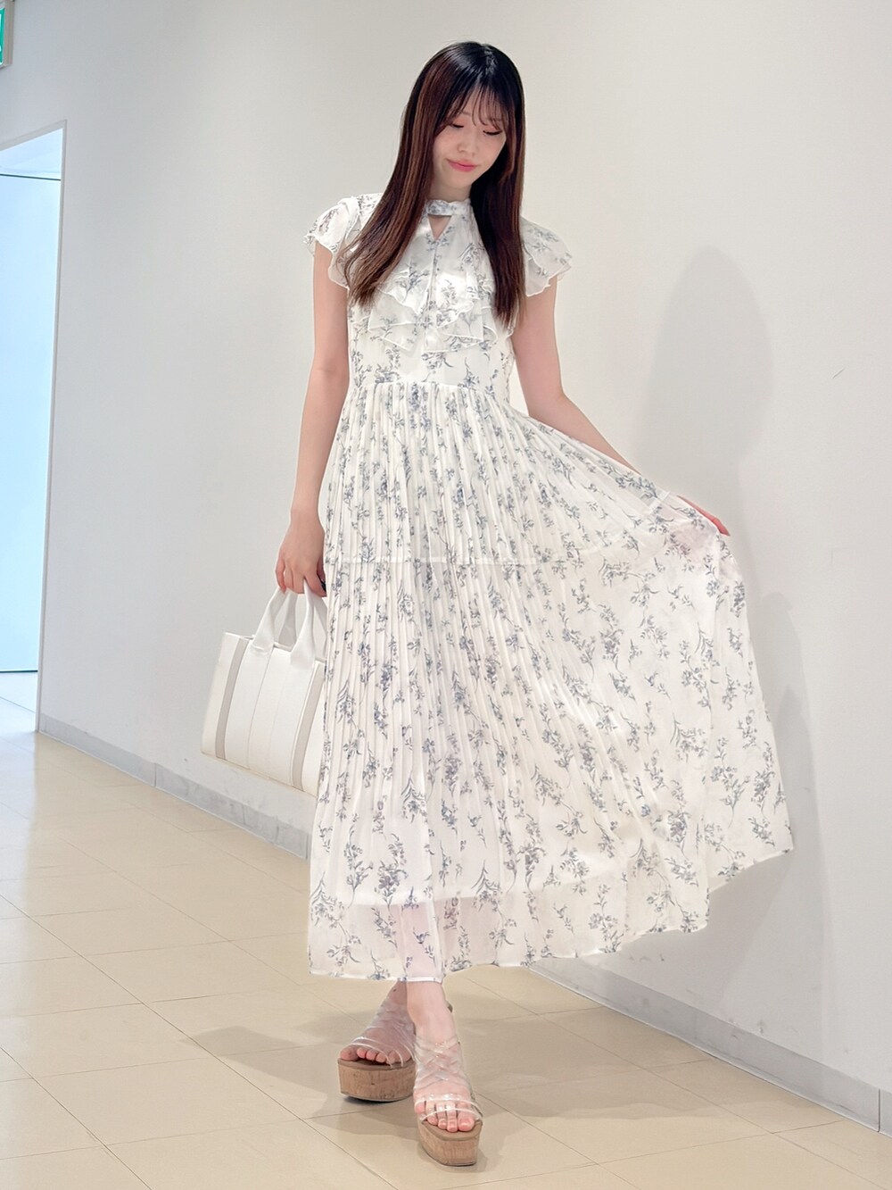 ホワイト系のワンピース、ホワイト系のトートバッグ、その他のサンダルを着用したレディースの春コーディネートの3枚目の写真