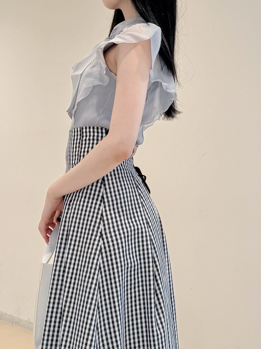 グレー系のニット/セーター、その他のスカート、ホワイト系のトートバッグを着用したレディースの春コーディネートの6枚目の写真