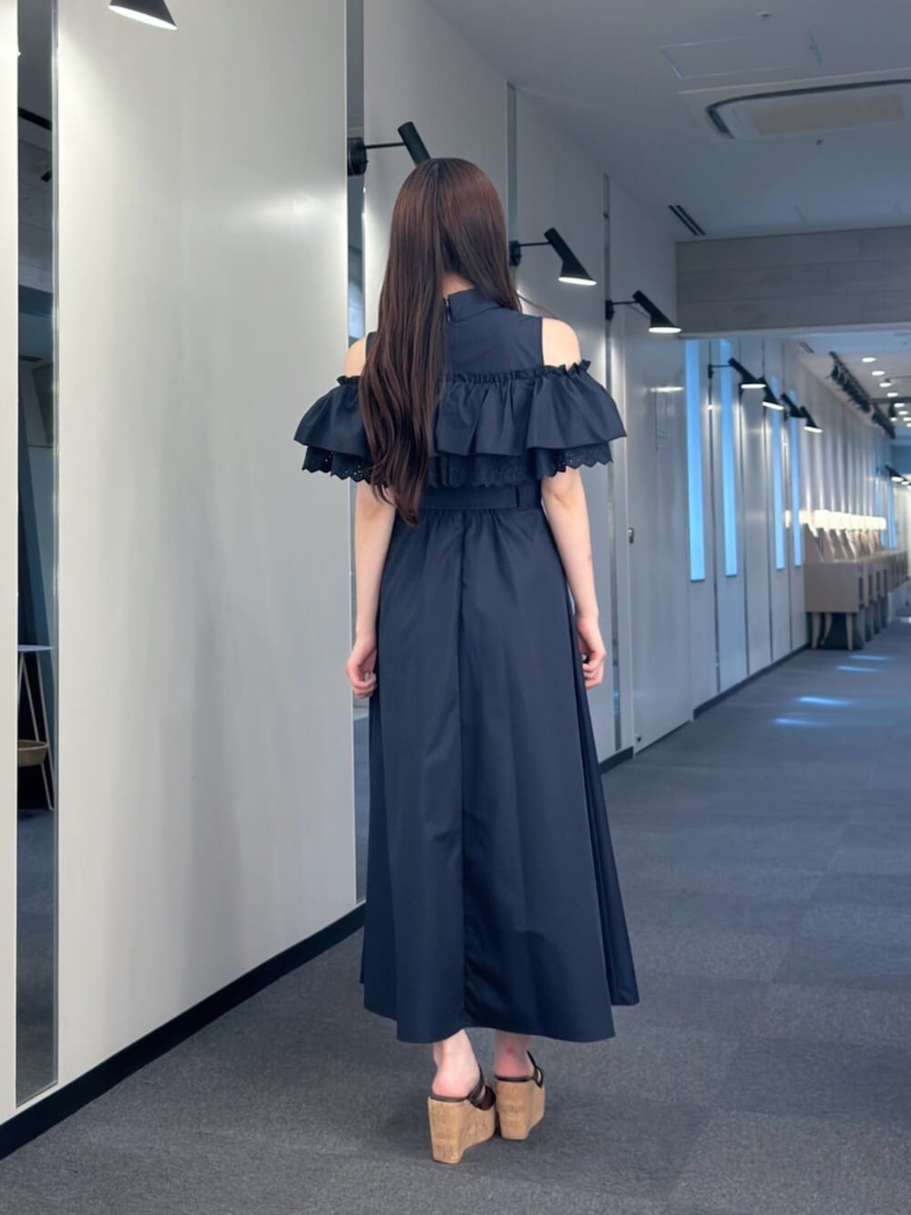 ホワイト系のハンドバッグ、ブラウン系のサンダル、ブルー系のワンピースを着用したレディースの夏コーディネートの5枚目の写真