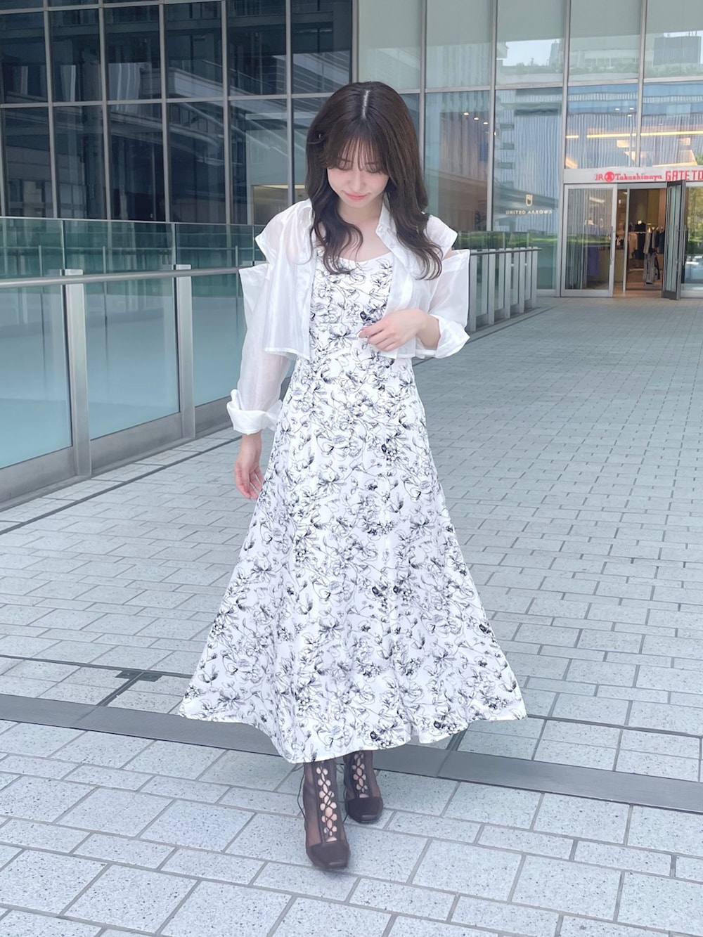 ホワイト系のワンピース、ブラウン系のブーツを着用したレディースの夏コーディネートの2枚目の写真