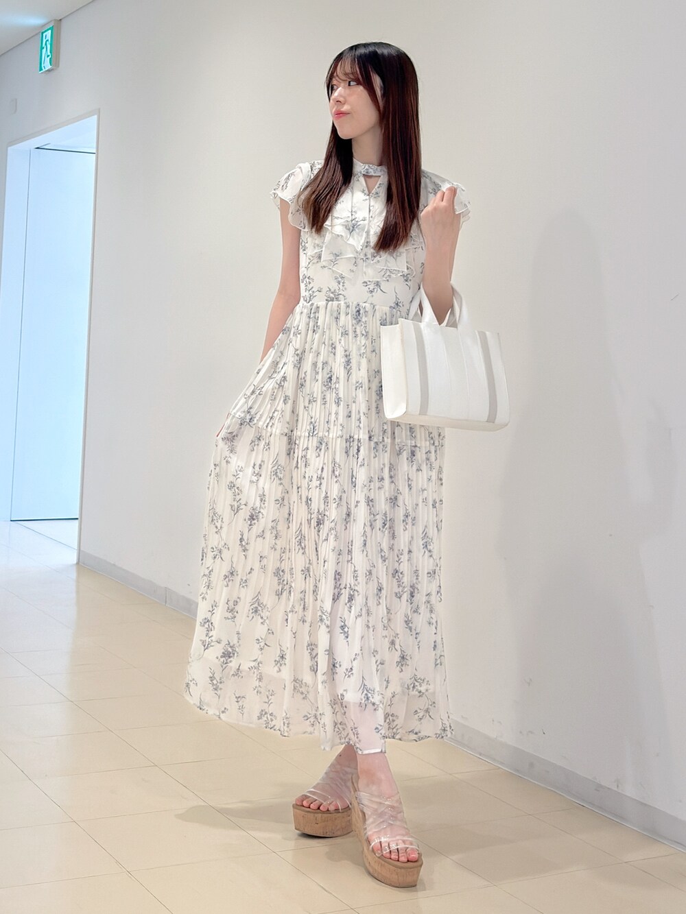 ホワイト系のワンピース、ホワイト系のトートバッグ、その他のサンダルを着用したレディースの春コーディネートの2枚目の写真