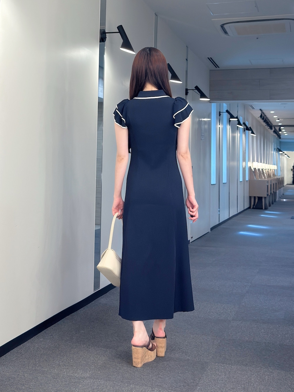 ブルー系のワンピース、ホワイト系のハンドバッグ、ブラウン系のサンダルを着用したレディースの夏コーディネートの4枚目の写真