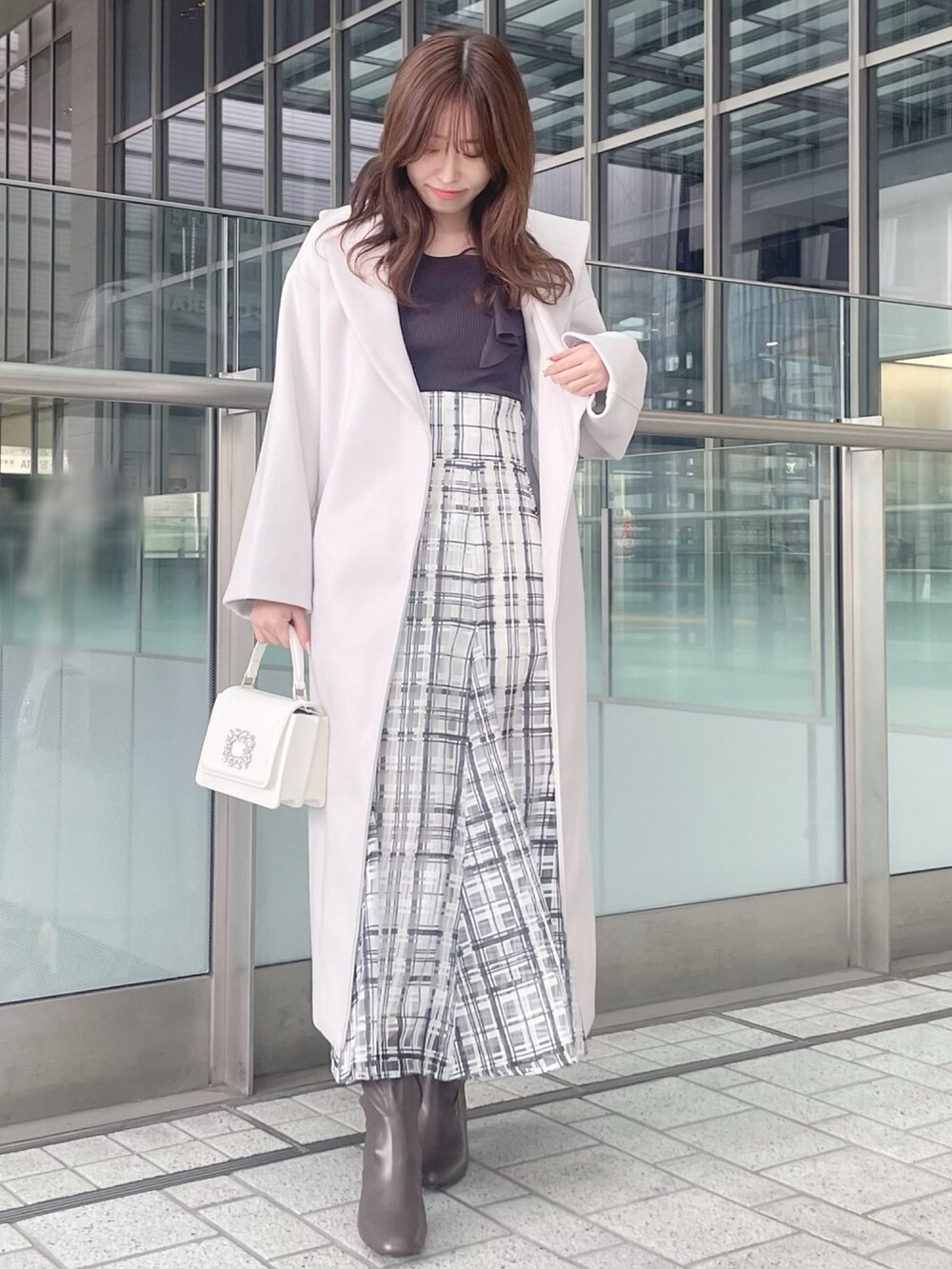 ホワイト系のショルダーバッグ、グレー系のニット/セーター、ホワイト系のチェスターコートを着用したレディースの冬コーディネートの2枚目の写真