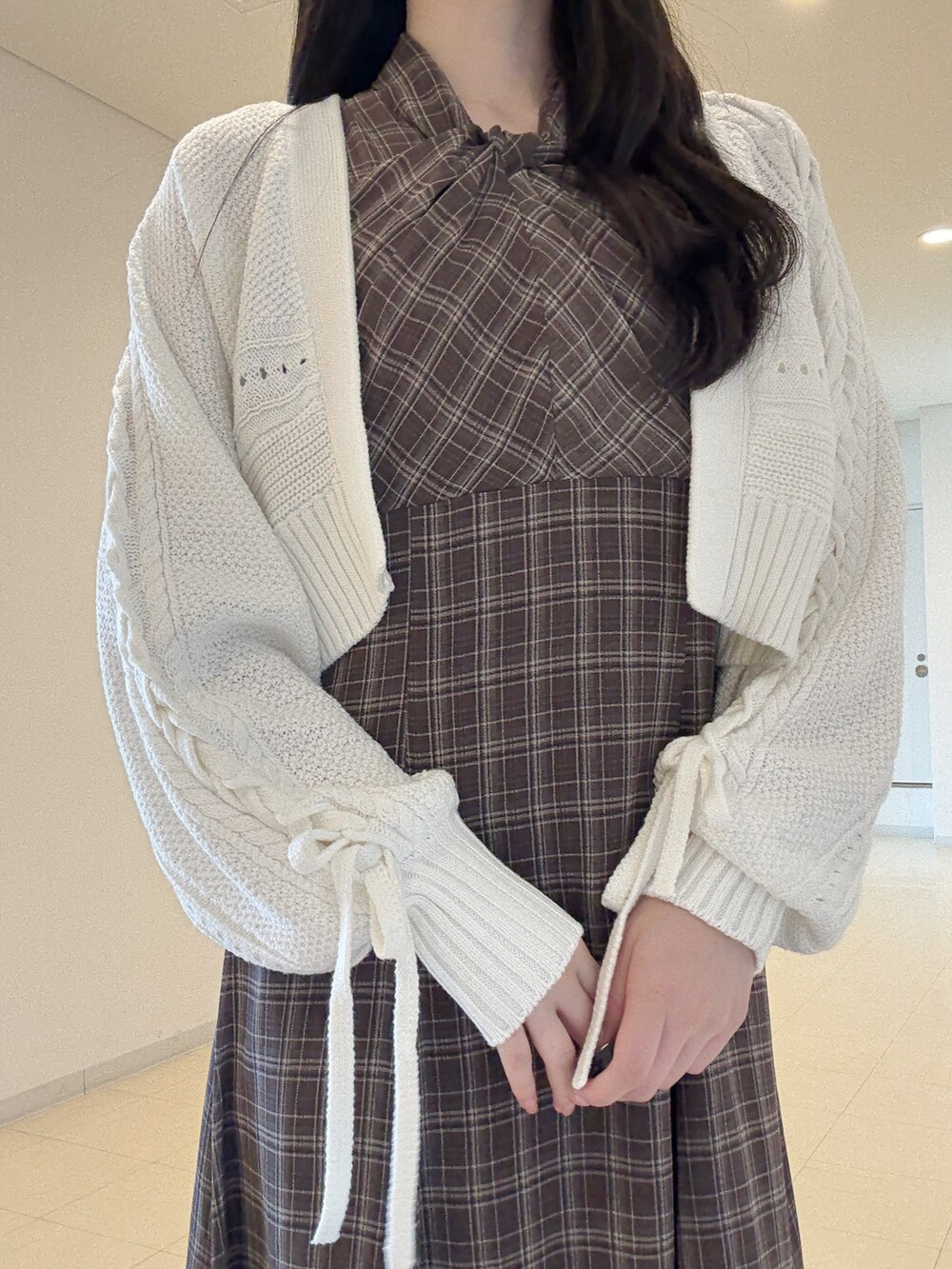 ホワイト系のカーディガン/ボレロ、ブラウン系のワンピース、ブラック系のブーツを着用したレディースの夏コーディネートの7枚目の写真