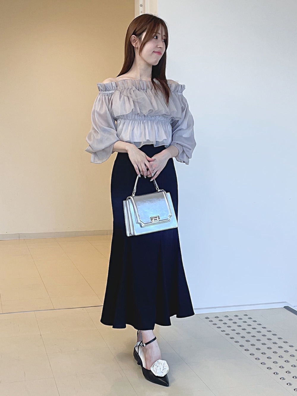 パープル系のシャツ/ブラウス、ブラック系のスカート、シルバー系のハンドバッグを着用したレディースの夏コーディネートの2枚目の写真