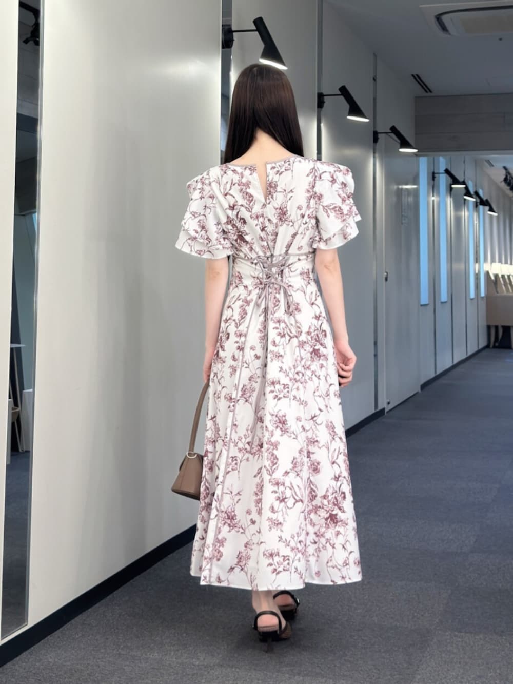 ブラウン系のハンドバッグ、ブラウン系のパンプス、レッド系のワンピースを着用したレディースの夏コーディネートの4枚目の写真