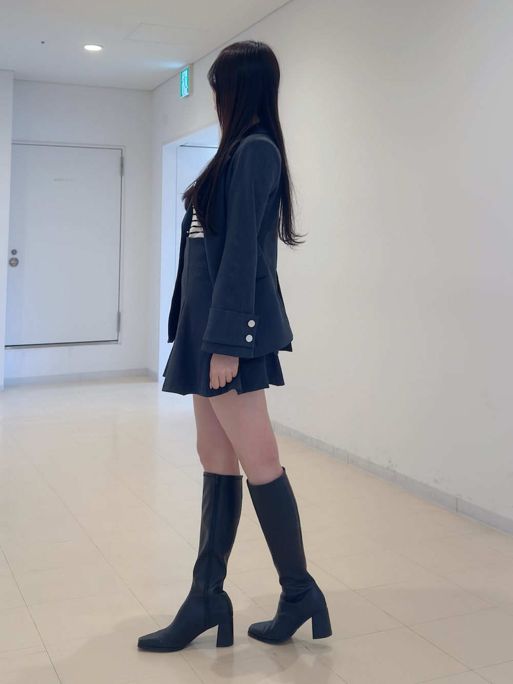 グレー系のテーラードジャケット、その他のニット/セーター、グレー系のスカートを着用したレディースの冬コーディネートの3枚目の写真