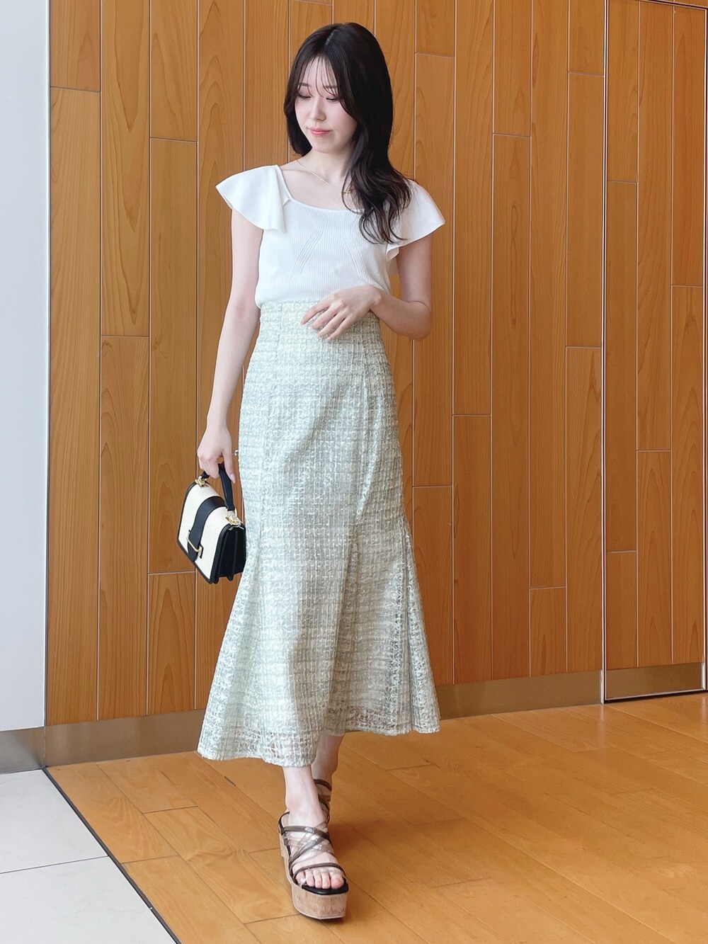 ベージュ系のシャツ/ブラウス、ホワイト系のニット/セーター、グリーン系のスカートを着用したレディースの春コーディネートの5枚目の写真