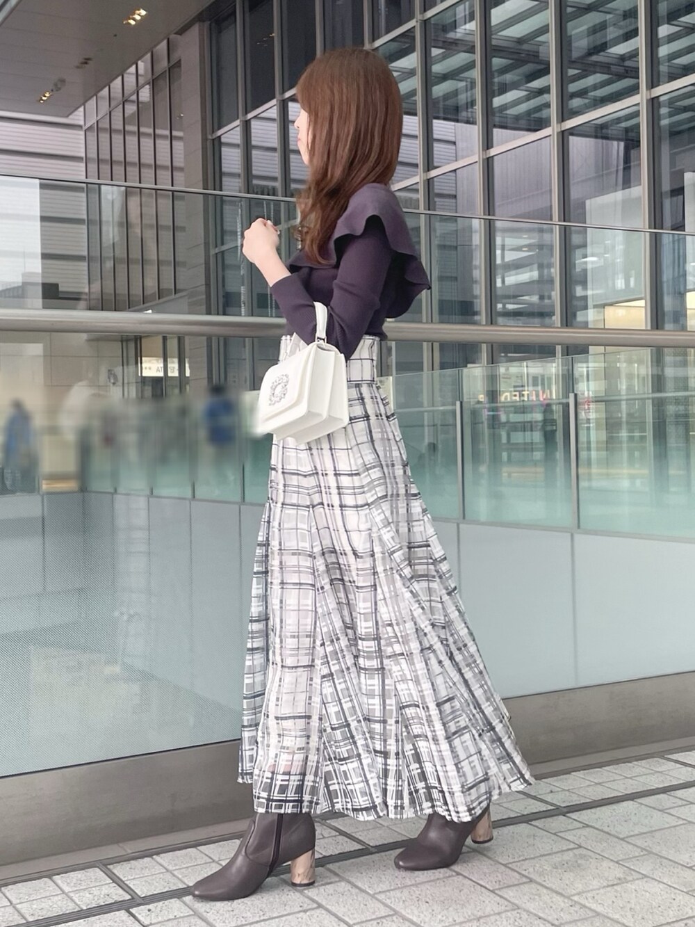 ホワイト系のショルダーバッグ、グレー系のニット/セーター、ホワイト系のチェスターコートを着用したレディースの冬コーディネートの5枚目の写真