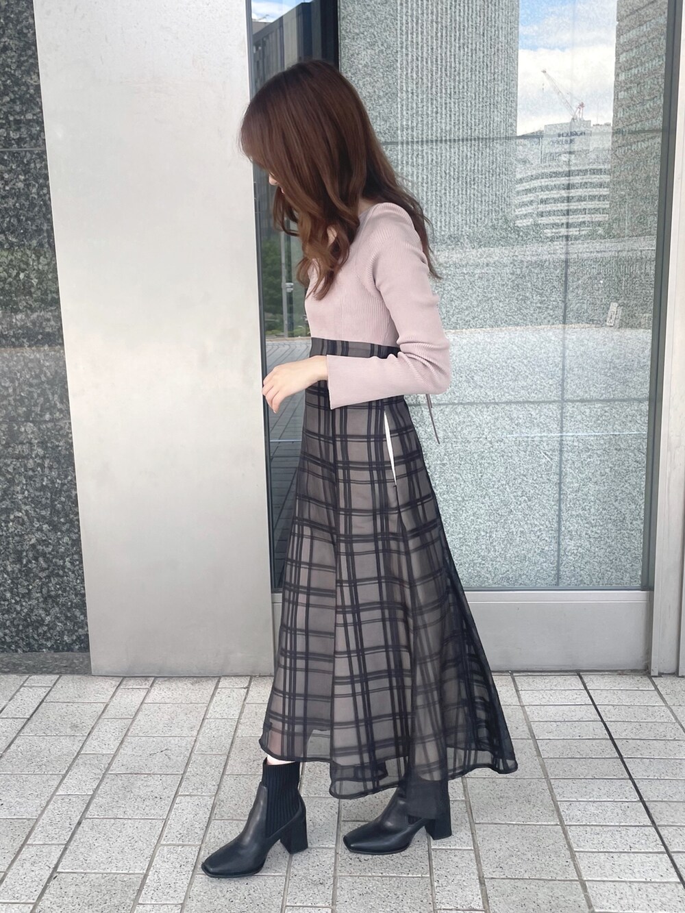 ピンク系のワンピース、ブラック系のショルダーバッグ、ブラック系のブーツを着用したレディースの秋コーディネートの5枚目の写真