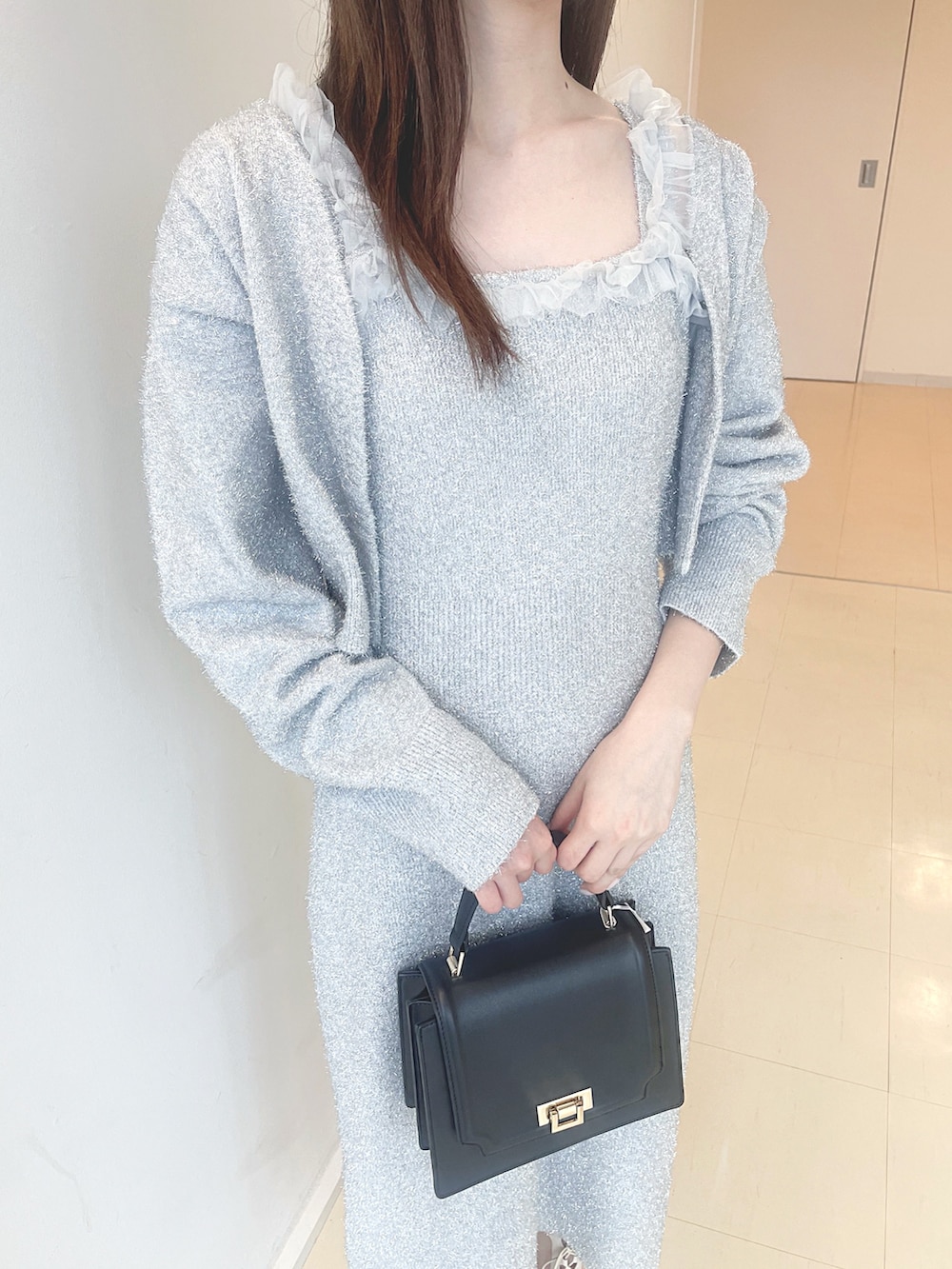 ホワイト系のブーツ、ブラック系のハンドバッグ、シルバー系のワンピースを着用したレディースの秋コーディネートの7枚目の写真