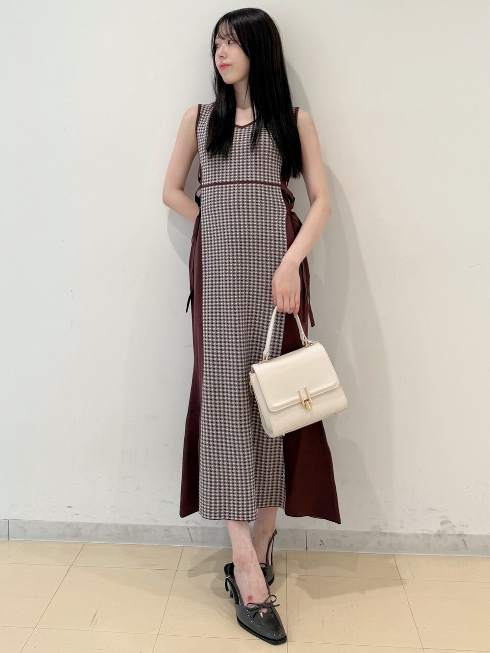 ブラウン系のワンピース、ホワイト系のハンドバッグ、グレー系のパンプスを着用したレディースの夏コーディネートの4枚目の写真