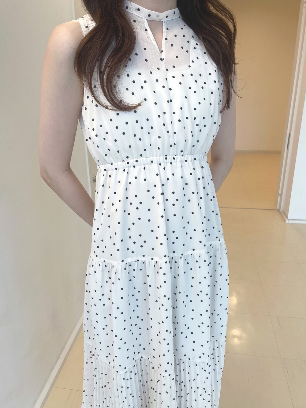 ホワイト系のワンピース、ブラック系のサンダル、シルバー系のイヤリングを着用したレディースの夏コーディネートの4枚目の写真