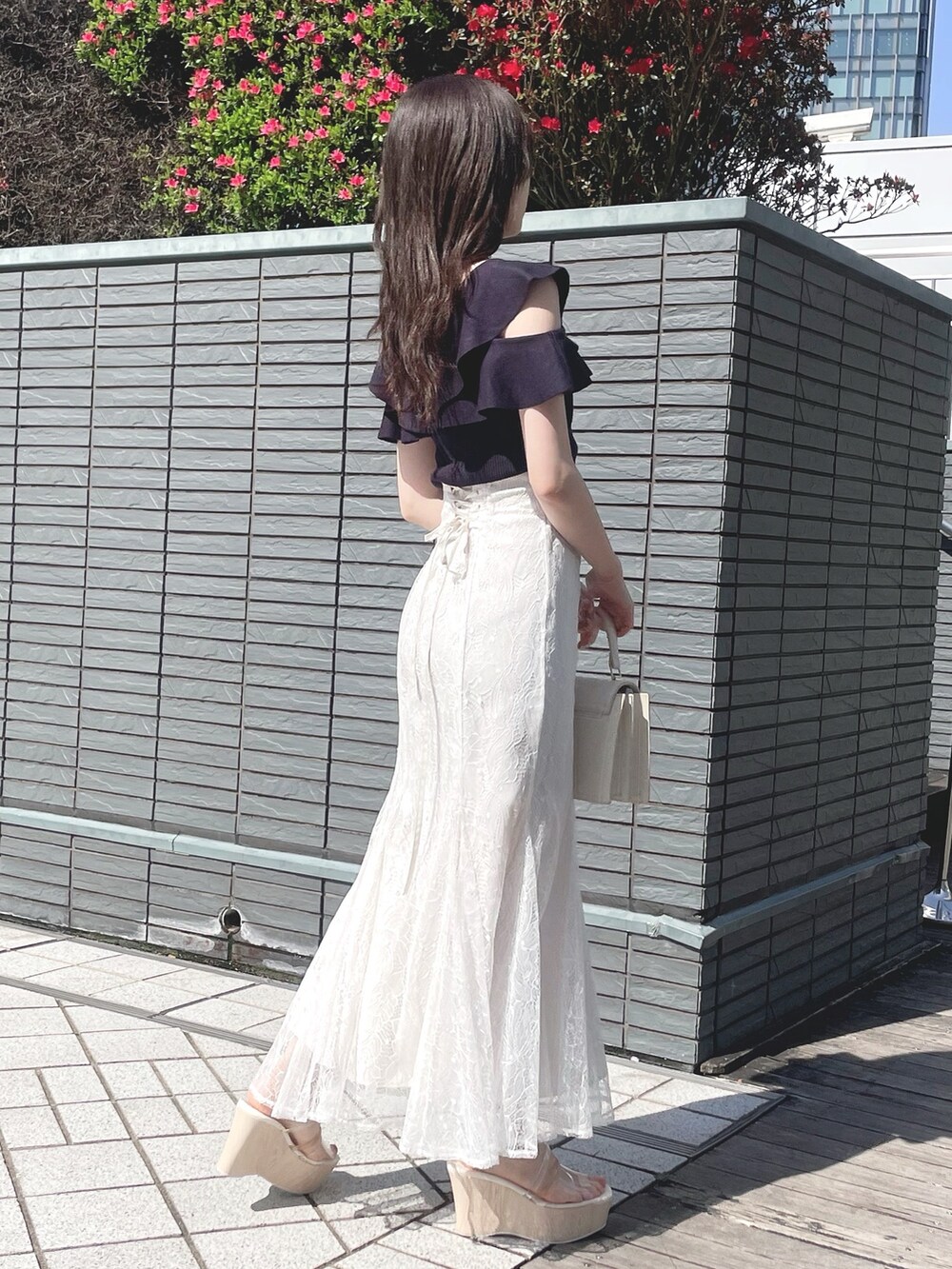 ブルー系のニット/セーター、ホワイト系のスカート、ホワイト系のハンドバッグを着用したレディースの春コーディネートの5枚目の写真