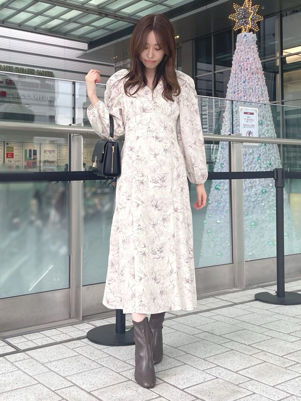 ホワイト系のカーディガン/ボレロ、ホワイト系のワンピース、ブラック系のショルダーバッグを着用したレディースの秋コーディネートの6枚目の写真