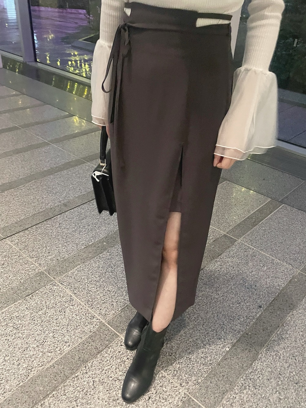 ホワイト系のテーラードジャケット、ホワイト系のニット/セーター、グレー系のスカートを着用したレディースの冬コーディネートの10枚目の写真